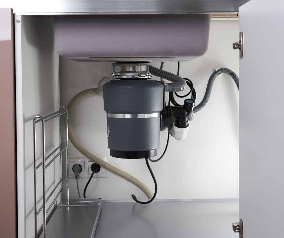 A garbage disposal under a sink in a home